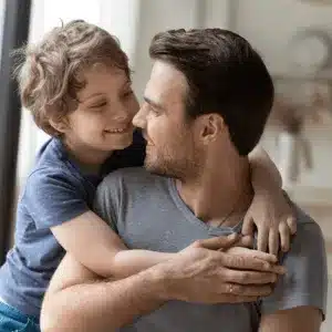 Smiling father and son embrace after resolving how do I file for custody of my child