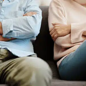 A couple sits apart with folded arms during tense discussions about annulment in Montana