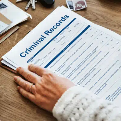Person holding a criminal records form on a desk, showing paperwork needed for expungement Montana